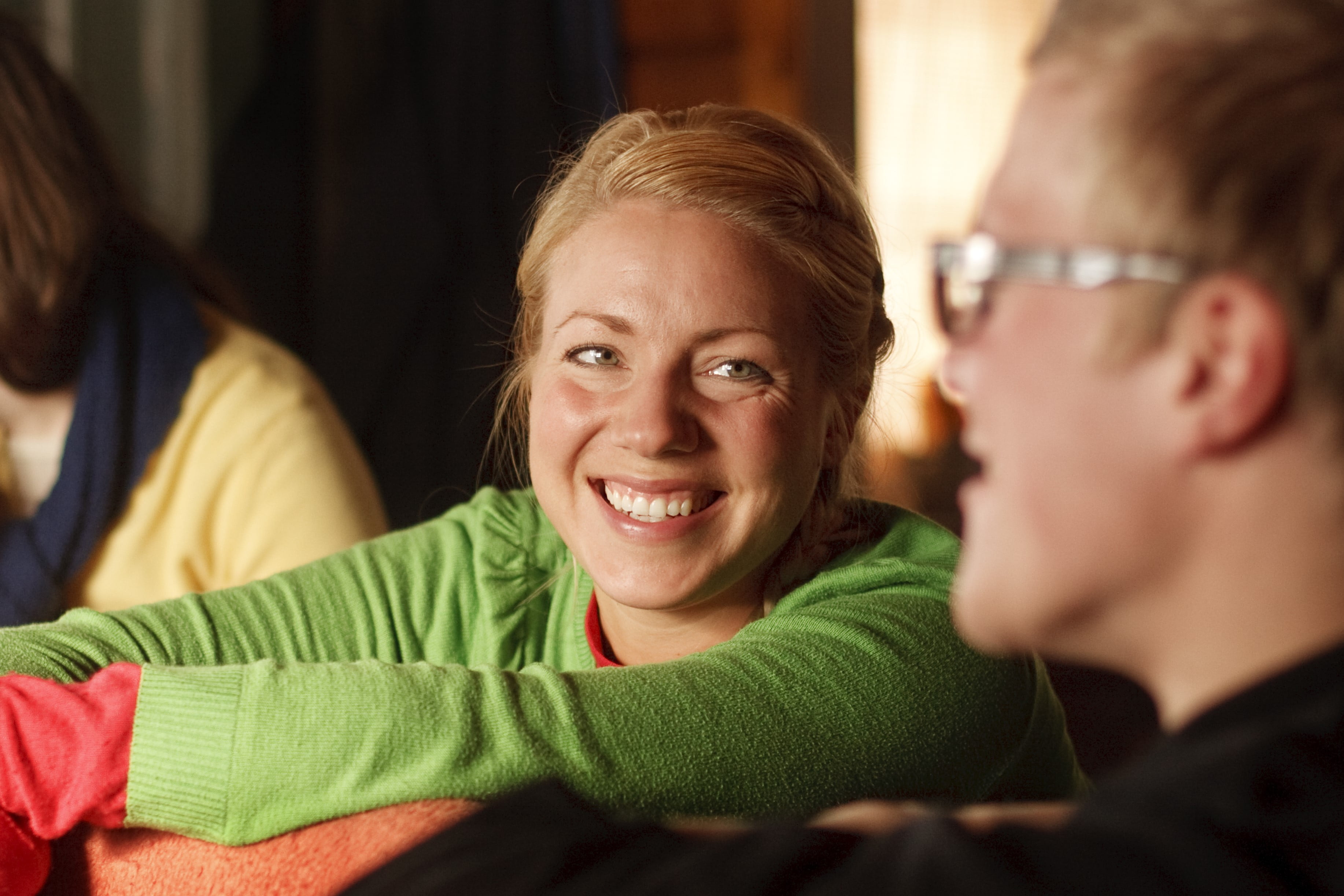 Dame i grønn genser smiler til venn