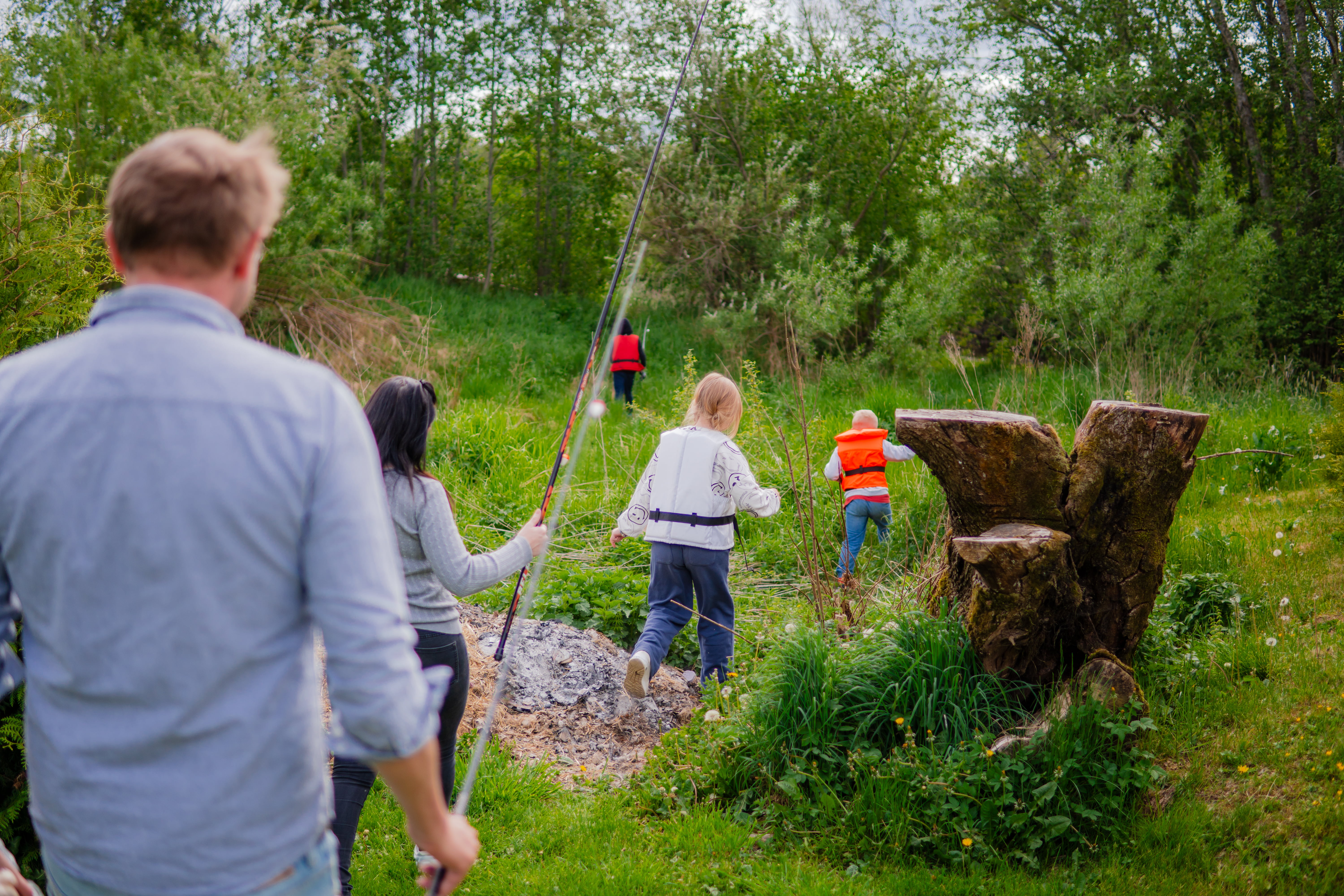En familie på vei til et sted for å fiske. De bærer fiskeutstyr.