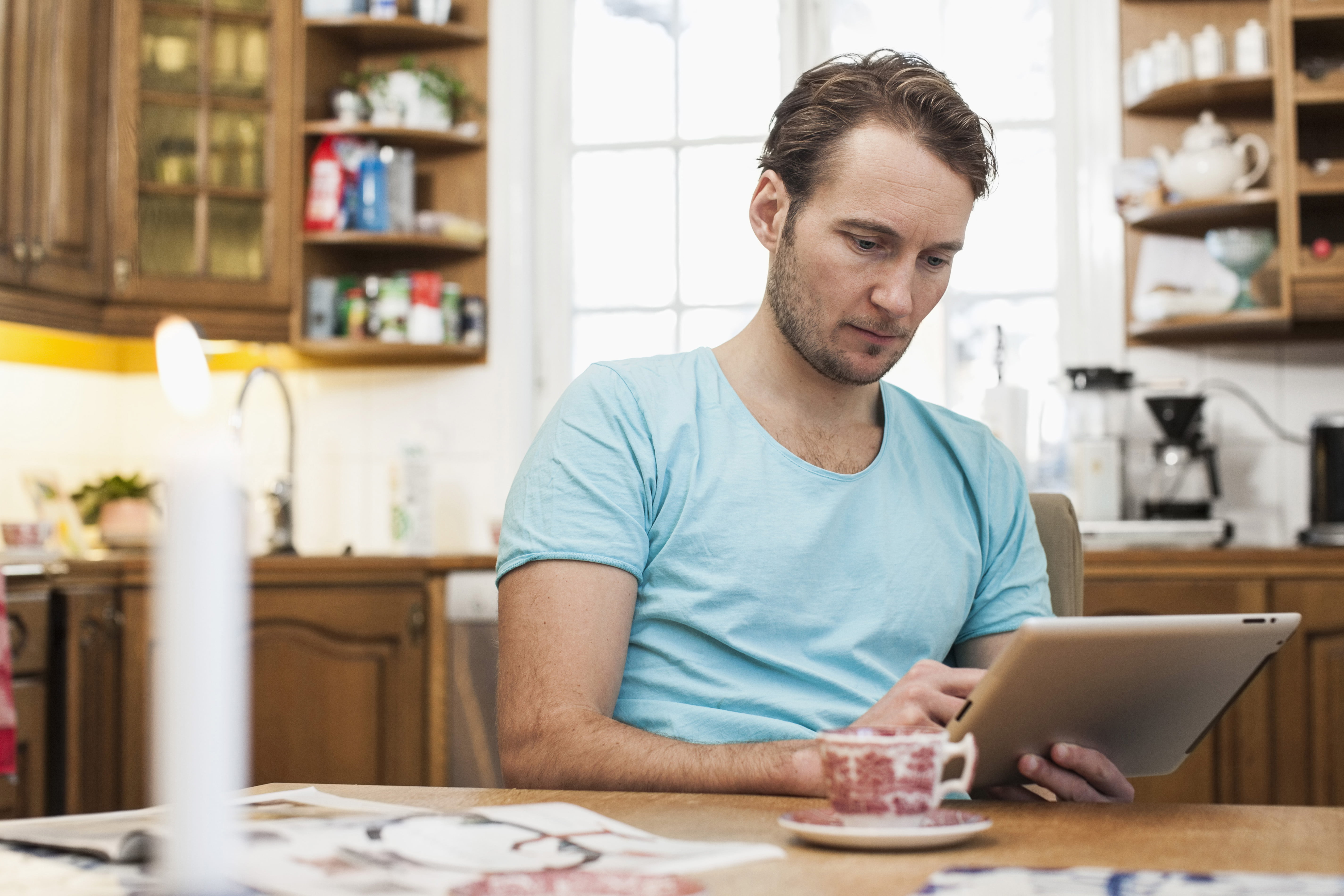 Mann på kjøkkenet med ipad